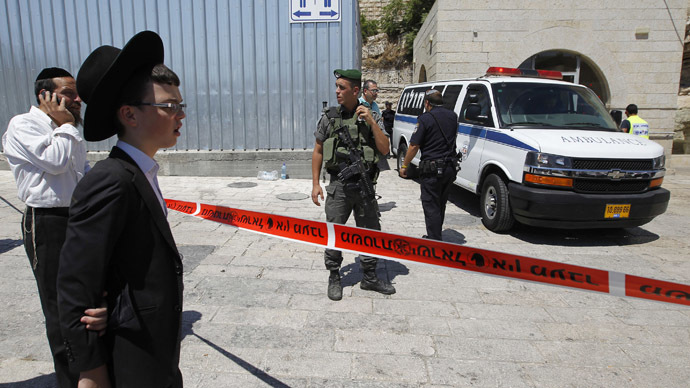 An ultra-Orthodox Jewish youth (2nd L) stands near a police cordon at the site of a shooting incident near the Western Wall in Jerusalem's Old City June 21, 2013. (Reuters)