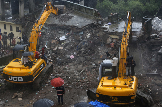 Rescue workers use excavators to scour the debris for survivors at the site of a collapsed residential building in Mumbra, in Thane district, on the outskirts Mumbai June 21, 2013. (Reuters/Vivek Prakash)