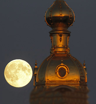 The moon rises behind the Peter and Pawel Fortress in St. Petersburg June 22, 2013. (Reuters / Alexander Demianchuk)