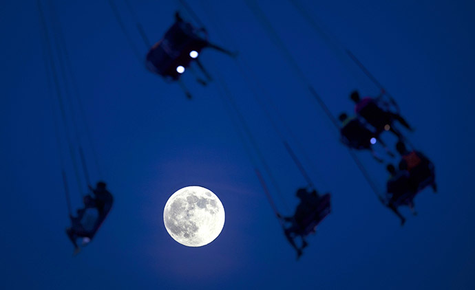 People ride the Luna Park Swing Ride as the Super Moon rises on Coney Island, June 22, 2013. (Reuters / Carlo Allegri)