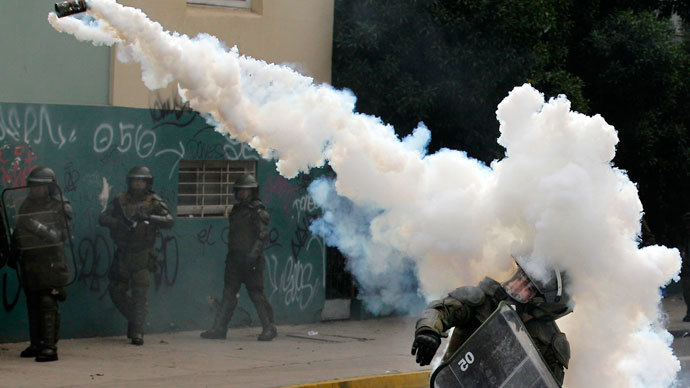 A riot police officer throws a tear gas canister at students during a demonstration against the government to demand changes in the public state education system in Valparaiso city, about 121 km (75 miles) northwest of Santiago, June 26, 2013.(Reuters / Eliseo Fernandez)