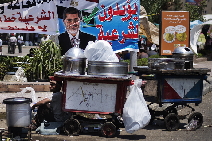 A street vendor sits by his cart as supporters of Egyptian President Mohamed Morsi and the Muslim Brotherhood camp outside the Rabaa al-Adawiya mosque in Cairo during a sit-in to show their support to Morsi on June 29, 2013 (AFP Photo / Gianluigi Guercia)