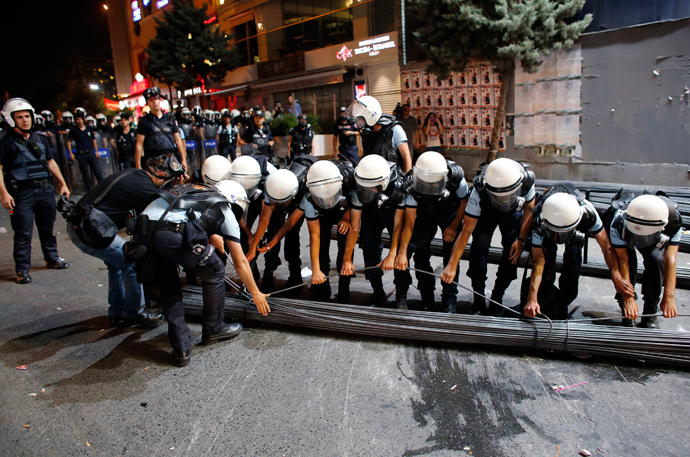 Riot police remove iron bars from a barricade to open the road to the traffic during an anti-government protest at Taksim Square in Istanbul June 29, 2013 (Reuters / Umit Bektas)