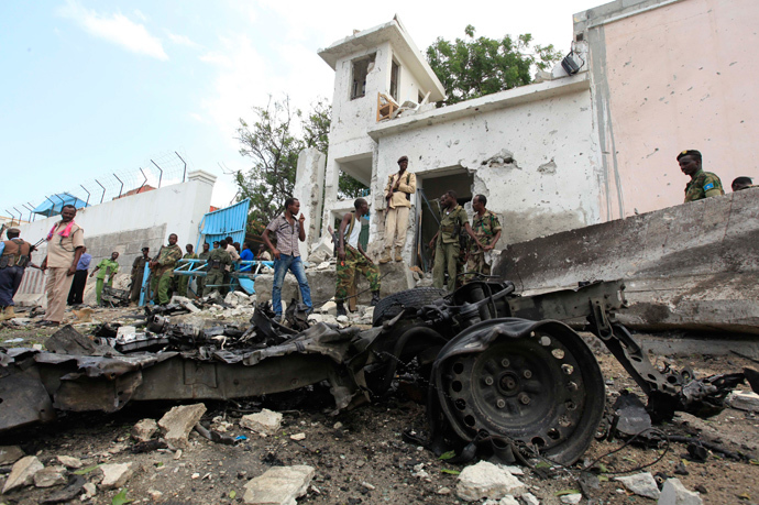 Security agents stand near the scene of a suicide bomb attack outside the United Nations compound in Somalia's capital Mogadishu, June 19, 2013 (Reuters / Feisal Omar) 