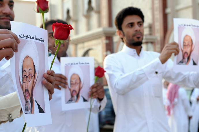 Supporters of Saudi Shi'ite cleric Tawfiq al-Amer hold his pictures during a demonstration following his release in Al-Ahs (Reuters / Stringer)