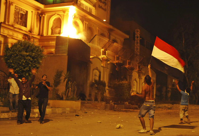 Protesters opposing Egyptian President Mohamed Morsi wave an Egyptian flag and shout slogans against him and members of the Muslim Brotherhood after attacking its national headquarters Molotov cocktails in Cairo's Moqattam district June 30, 2013. (Reuters)