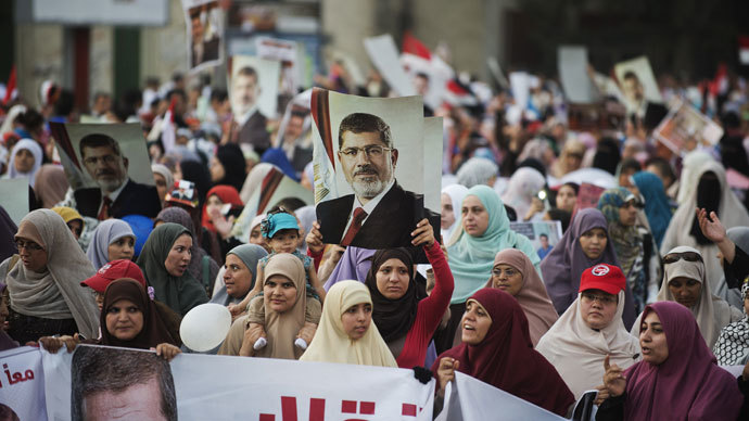 Egyptian women from the Muslim Brotherhood hold portraits of ousted President Mohammed Morsi as they march in his support on August 11, 2013 in Cairo.(AFP Photo / Gianluigi Guercia)