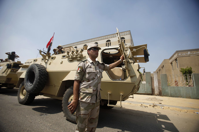 An army officer stands by an armoured personnel carrier deployed on a road leading to the Raba El-Adwyia mosque square where supporters of Egypt's deposed President Mohamed Morsi are camping, in Cairo July 4, 2013. (Reuters/Khaled Abdullah)