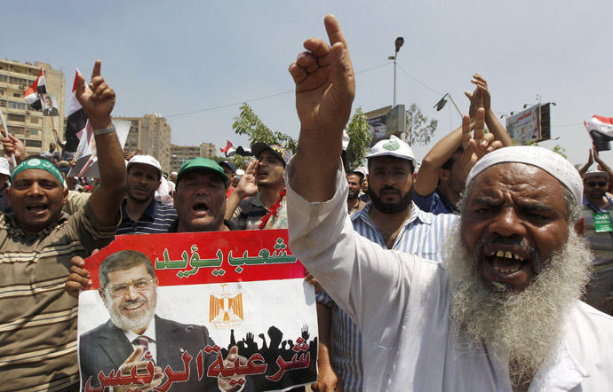 Members of the Muslim Brotherhood and supporters of ousted Egyptian President Mohamed Morsi hold a poster of him as they shout slogans at the Raba El-Adwyia mosque square in Cairo July 4, 2013. (Reuters/Louafi Larbi)