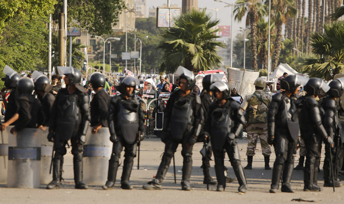 Protesters supporting former Egyptian President Mohamed Morsi demonstrate behind riot policemen near Cairo University in Cairo July 4, 2013. (Reuters/Suhaib Salem)