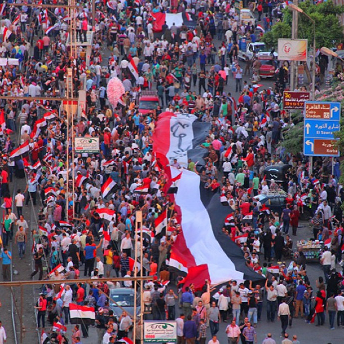 A group marches around the presidential palace protest carrying a huge Egyptian flag. (Photo from Instagram/@RT)