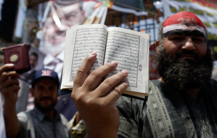A supporter of deposed Egyptian President Mohamed Mursi holds a copy of the Koran during a protest at the Rabaa Adawiya square, where they are camping at, in Cairo July 11, 2013 (Reuters / Amr Abdallah Dalsh)