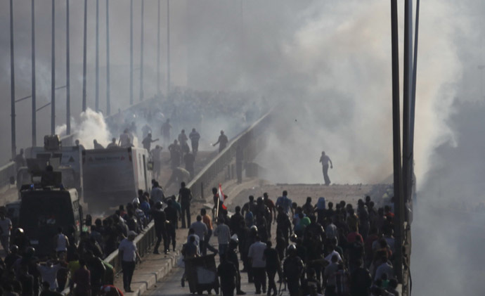 Members of the Muslim Brotherhood and supporters of ousted Egyptian President Mohamed Mursi flee from tear gas and rubber bullets fired by riot police during clashes, on a bridge leading to Rabba el Adwia Square where they are camping, in Cairo August 14, 2013. (Reuters/Amr Abdallah Dalsh)