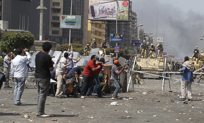 Members of the Muslim Brotherhood and supporters of ousted Egyptian President Mohamed Morsi throw stones at riot police and the army during clashes around the area of Rabaa Adawiya square, where they are camping, in Cairo August 14, 2013. (Reuters/Asmaa Waguih)