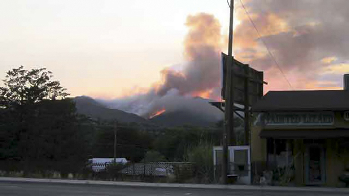 This still image from video provided courtesy of KPHO-TV / CBS-5-AZ.COM shows smoke rising from raging wildfires in the hills near Yarnell, Arizona on June 30, 2013. (AFP Photo / KPHO-TV/CBS-5-AZ.COM)