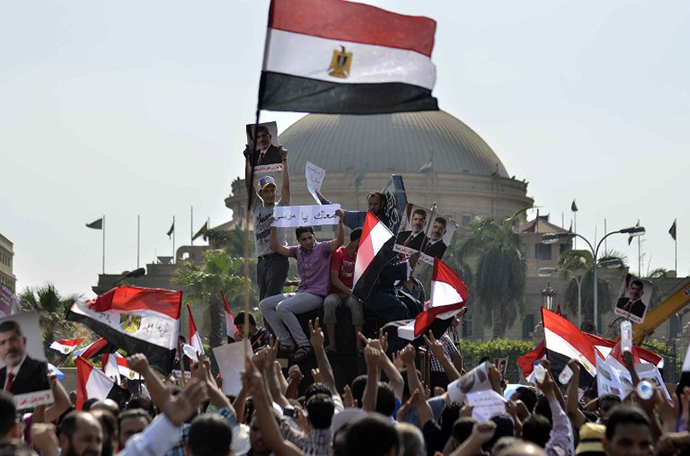 Supporters of Islamist Egyptian President Mohamed Morsi hold pictures of him during a rally by mainly Muslim Brotherhood partisans outside Cairo University on June 2, 2013. (AFP Photo / Mohamed El-Shahed)