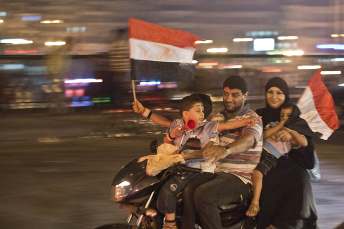 An Egyptian family on motorcycle celebrates in Cairo on July 3, 2013 after a broadcast confirming that the army will temporarily be taking over from the country's first democratically elected president Mohammed Morsi (AFP Photo / Khaled Desouki) 