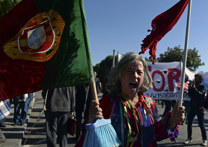 A demonstrator shouts slogans and waves a Portuguese flag on a broom stick during a protest against governments policies in front of Belem presidential palace in Lisbon on May 20, 2013, as Portuguese President Anibal Cavaco Silva (unseen) gathers the State Coucil, his advisers body. (AFP Photo)