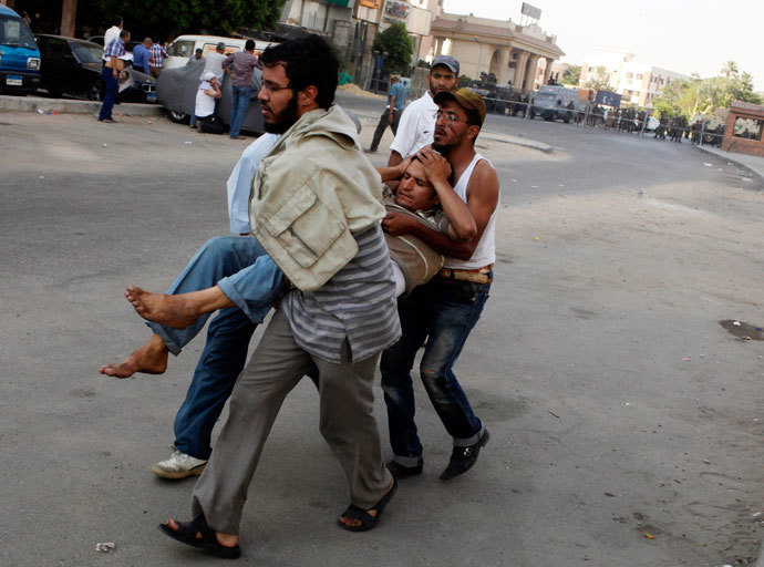 Protesters, who support former Egyptian President Mohamed Mursi, carry an injured man during clashes outside the Republican Guard building in Cairo July 5, 2013.(Reuters / Asmaa Waguih)