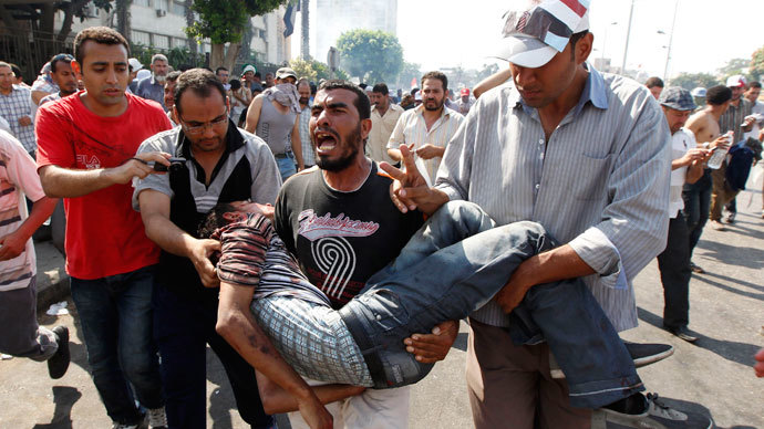 Protesters who support former Egyptian President Mohamed Mursi carry an injured man during clashes outside the Republican Guard building in Cairo July 5, 2013.(Reuters / Louafi Larbi)
