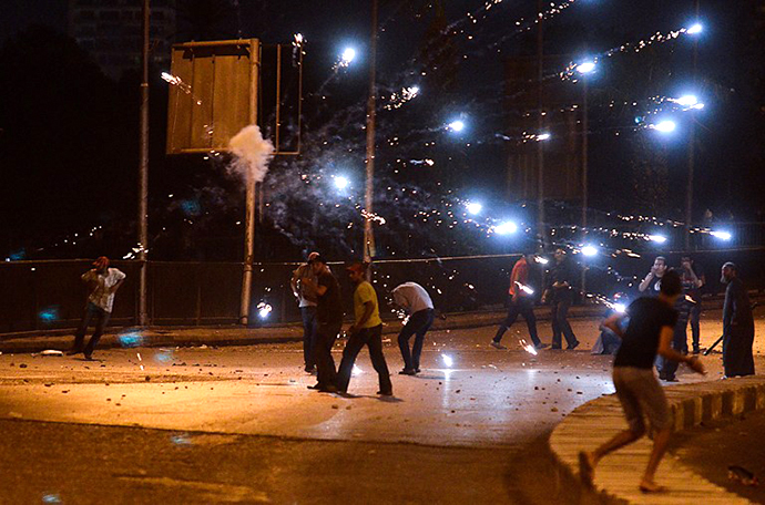 Ousted president Mohamed Morsi supporters and anti Morsi protesters hurl stones at each other as they clash near Egypt's landmark Tahrir square on July 5, 2013 in Cairo. (AFP Photo / Mohamed El-Shahed)