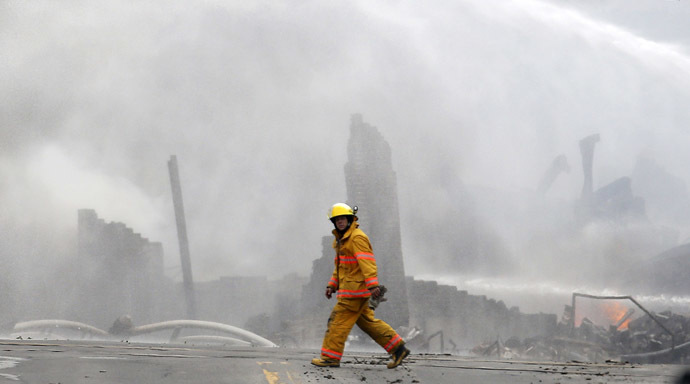 A firefighter walks past the remains of buildings after a train explosion at Lac Megantic, Quebec, July 6, 2013. (Reuters/Mathieu Belanger)