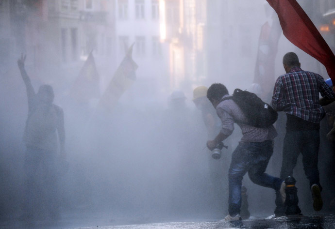  Protesters take cover from a water cannon during clashes with police on Istiklal Avenue in Istanbul on July 6, 2013. (AFP Photo/Bulent Kilic)