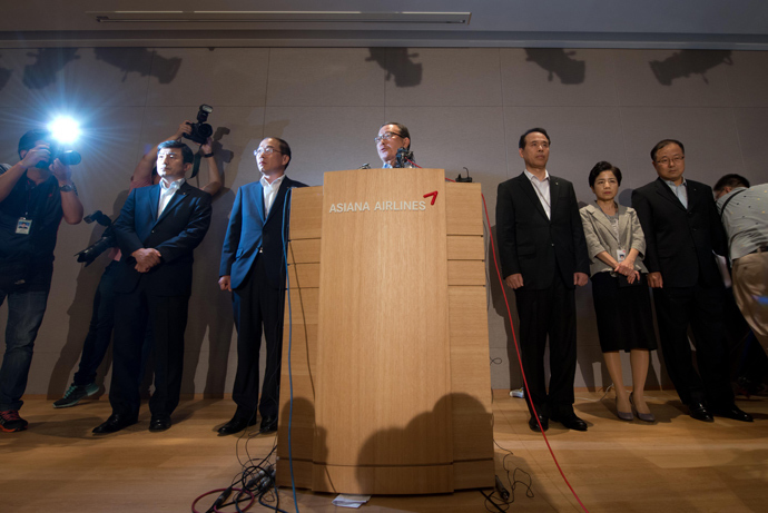 Asiana Airlines CEO Yoon Young-doo (C) stands with other executives as he makes a statement during a press conference at the company headquarters building in Seoul on July 7, 2013 (AFP Photo / Ed Jones)