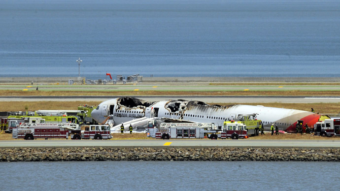 An Asiana Airlines Boeing 777 is seen on the runway at San Francisco International Airport after crash landing on July 6, 2013. (AFP Photo/Josh Edelson)