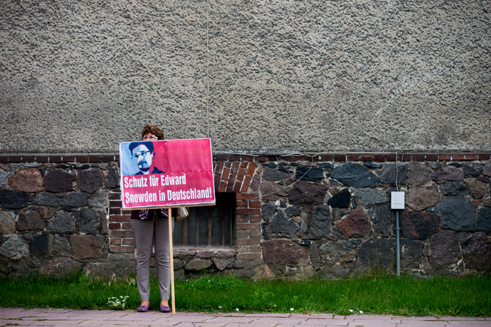 A supporter of German left-wing party Die Linke holds a placard in support of former US spy agency, NSA, contractor Edward Snowden in the village of Loewenberg, some 60 km (37 miles) north of Berlin, July 4, 2013 (Reuters / Thomas Peter)