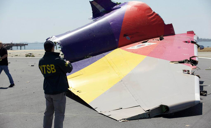 A National Transportation Safety Board (NTSB) investigator looks at the tail section of the Asiana Airlines Flight 214 that crashed at San Francisco International Airport in San Francisco, California in this handout photo released on July 7, 2013 (Reuters / NTSB / Handout via Reuters)