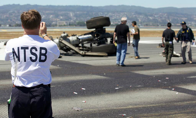 U.S. National Transportation Safety Board (NTSB) investigators attend to the scene of the Asiana Airlines Flight 214 crash site at San Francisco International Airport in San Francisco, California in this handout photo released on July 7, 2013 (Reuters / NTSB / Handout via Reuters)