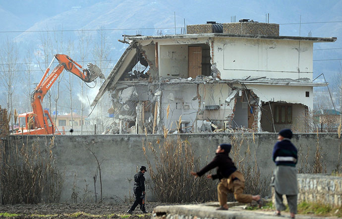 Young Pakistani boys play near demolition works on the compound where Al-Qaeda chief Osama bin Laden was slain last year in the northwestern town of Abbottabad on February 26, 2012. (AFP Photo / Aamir Qureshi)