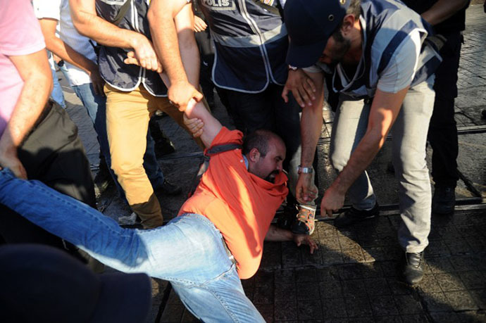 Turkish riot policemen arrest a protestor during clashes with police on Taksim sqaure in Istanbul on July 8, 2013. (AFP Photo / Bulent Kilic)