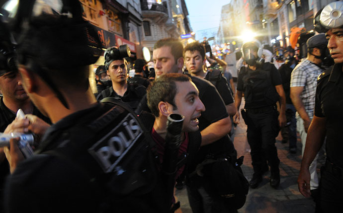 Turkish riot policemen arrest a protestor during clashes with police on Taksim square in Istanbul on July 8, 2013. (AFP Photo / Bulent Kilic)