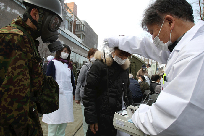 An official scans for signs of radiation on a woman in Nihonmatsu City in Fukushima Prefecture March 13, 2011 after radiation leaked from an earthquake-damaged Fukushima Daini nuclear reactor (Reuters / Yomiuri Shimbun)
