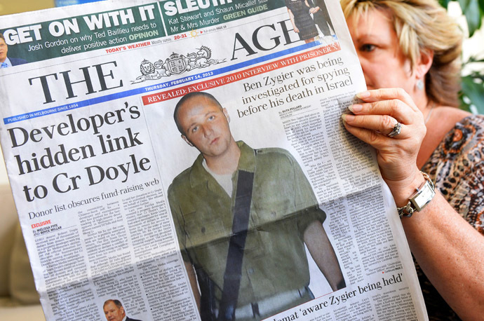 In this photo illustration taken in Sydney on February 14, 2013, a woman poses with an Australian newspaper showing the front page story of Ben Zygier, as Israel confirms it jailed a foreigner in solitary confinement on security grounds who later committed suicide, with Australia admitting it knew one of its citizens had been detained. (AFP Photo/William West)