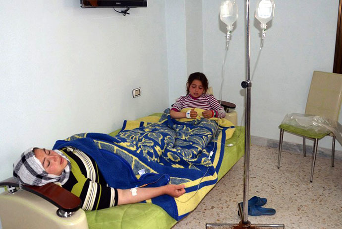 In this image made available by the Syrian News Agency on March 19, 2013, a woman and a girl rest on a mattress at a hospital in the Khan al-Assal region in the northern Aleppo province, as Syria's government accused rebel forces of using chemical weapons for the first time. (AFP Photo / SANA)
