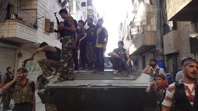 Syrian rebel fighters gather around a former Syrian army tank as rebels prepare to attack positions held by the Syrian army areas in the Salaheddine neighborhood of Aleppo, on July 8, 2013. (AFP Photo / Abo Mhio)