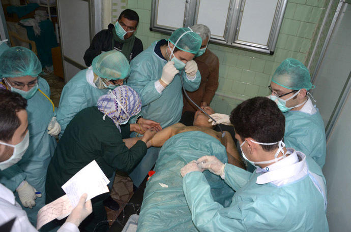 In this image made available by the Syrian News Agency (SANA) on March 19, 2013, medics and other masked people attend to a man at a hospital in Khan al-Assal in the northern Aleppo province, as Syria's government accused rebel forces of using chemical weapons for the first time. (AFP Photo/SANA)