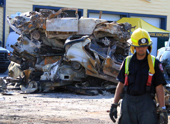 This photo provided July 8, 2013 by Surete du Quebec, shows a firefighter and a pile of burnt cars and debris left from a train derailment and exposion in Lac-Megantic, Quebec, Canada (AFP Photo)