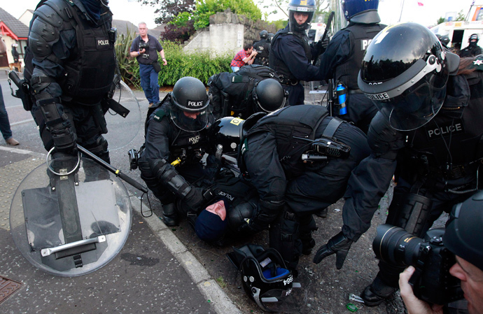 A police officer receives medical treatment after being injured as loyalists clashed with police in the Woodvale Road area of North Belfast, after an Orange Parade was blocked from marching past the Nationalist Ardoyne area in Belfast July 12, 2013 (Reuters / Cathal McNaughton)