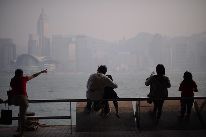 People sit in front of the city's skyline shrouded in a dense blanket of toxic smog in Hong Kong on April 15, 2013 (AFP Photo / Philippe Lopez) 