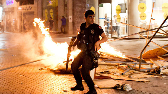 A Turkish riot policeman clashes with Turkish protestors on July 14, 2013 on Istiklal Avenue in the center of Istanbul.(AFP Photo / Gurcan Oztur)