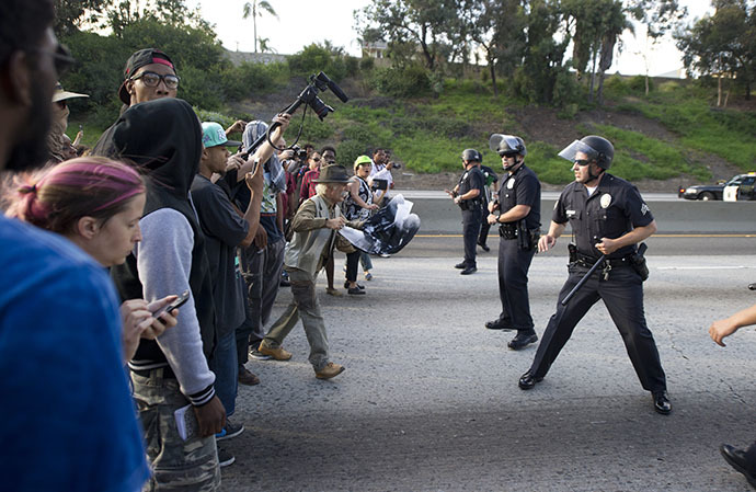 Police officers hold a line against protestors on the 10 Freeway after demonstrators angry at the acquittal of George Zimmerman in the death of black teen Trayvon Martin walk onto the 10 Freeway stopping highway traffic, in Los Angeles, California July 14, 2013. (AFP Photo / Robyn Beck)