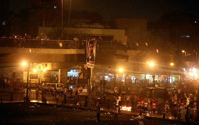 Supporters of the Muslim Brotherhood and of Egypt's ousted President Mohamed Morsi on July 16, 2013 hang a poster of the ousted leader on the Six October Bridge in the center of Cairo. (AFP Photo / Marwan Naamani)