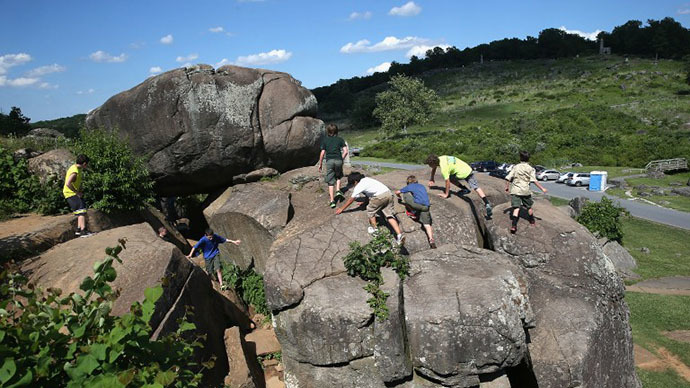 Boy scouts from Winchester, Virginia climb atop the boulders of "Devil's Den", in Gettysburg, Pennsylvania. (AFP Photo / John Moore)