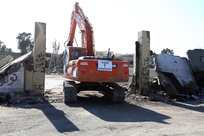 A digger moves in to tear down the external wall of Moamer Kadhafi's former compound of Bab al-Azizia , a Libyan landmark, on July 9, 2013, in the capital Tripoli (AFP Photo / Mahmud Turkia) 