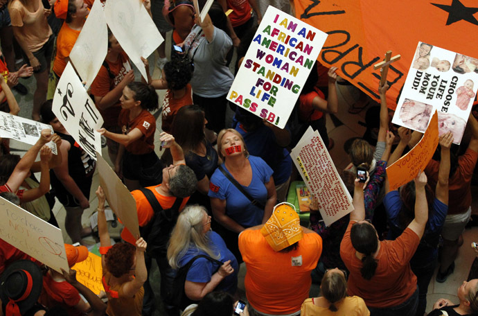 Abortion rights (in orange) and anti-abortion advocates (in blue) rally in the rotunda of the State Capitol, as the state Senate meets to consider legislation restricting abortion rights in Austin, Texas July 12, 2013. (Reuters/Mike Stone)