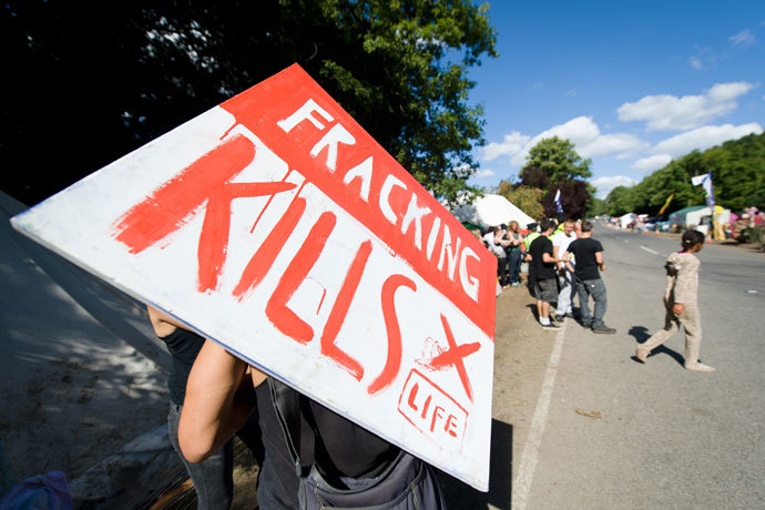  A climate and anti-fracking protester holds a "Fracking kills" placard as he stands outside the test drill site operated by British energy firm Cuadrilla Resources in Balcombe, southern England, on August 20, 2013.(AFP Photo / Leon Neal)